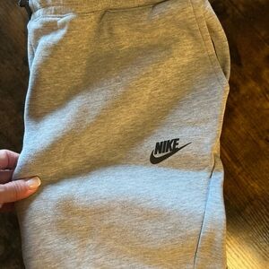Nike Tech Gray Jogger Pants with side black and gray zippers at pockets